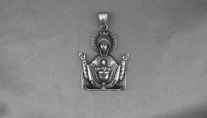 Macro view of vintage stainless steel Virgin Mary religious relief pendant on grey fabric