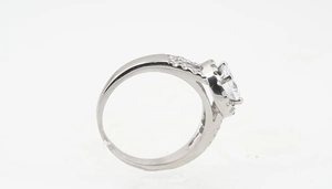Macro side view of silver titanium ring featuring a round center stone with pave halo
