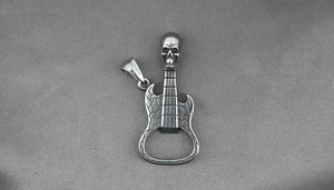 Close-up of guitar-shaped skull pendant with a bottle opener feature and retro metal texture