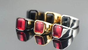Macro shot of mens signet rings with rectangular gemstones in gold, silver, and black finish