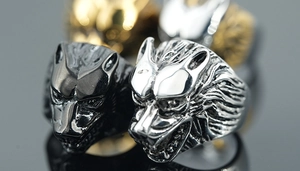 Macro detail of gothic wolf head rings showing intricate carvings and vintage metal textures