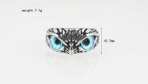 Vista detallada del anillo de búho vintage con ojos azules y textura de plumas