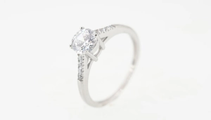 Macro shot of silver titanium ring with round brilliant cut diamond in classic claw setting