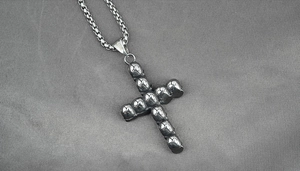Gros plan du pendentif croix crâne avec gravure S.STEEL et finition argentée vintage