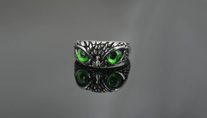 Detalle macro de anillo de búho retro con plumas texturizadas y ojos verdes vibrantes