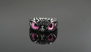 Detalle de los ojos del anillo de búho con cuentas moradas y relieve de plumas finas
