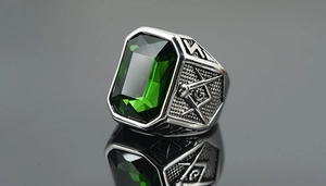 Detailed engraving of Masonic compass and square with green gemstone on steel ring