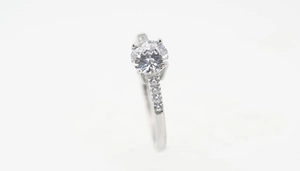 Macro shot of large round-cut diamond ring with pavé stones on a silver band