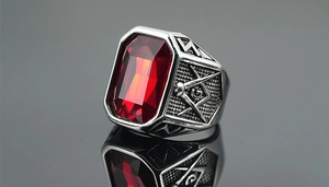 Macro detail of men's Masonic ring with large red rectangular stone and steel carving