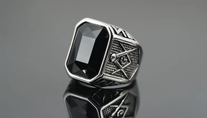 Macro detail of silver Freemason ring with black gemstone and square symbol
