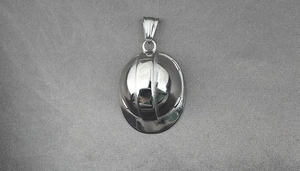 Detailed close-up of a silver-tone safety helmet pendant on a textured grey background