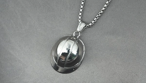 Macro shot of silver-tone hard hat pendant on a polished stainless steel box chain