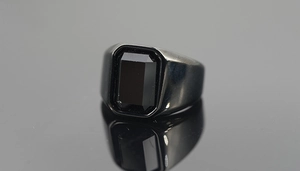 Macro shot of rectangular black gemstone and polished black metal finish on the ring