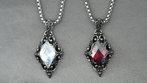 Detailed close-up of gothic rhombus pendants with red and white stones on box chains