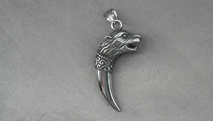 Détail du pendentif tête de loup en acier titane avec des textures nordiques complexes
