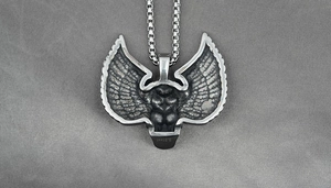 Détail du pendentif ailes argenté avec torse musclé et gravure S.Steel en acier