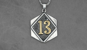 Detailed macro view of a hexagonal titanium steel pendant with golden number 13 engraving