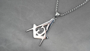 Detailed view of polished stainless steel Freemason symbol pendant on a classic box chain