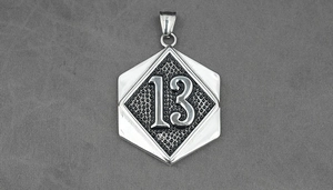 Macro shot of silver titanium steel hexagon pendant with embossed number 13