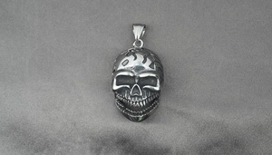 Vue détaillée du pendentif tête de mort punk avec gravures fines sur tissu gris