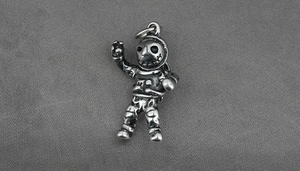 Close-up of a vintage astronaut pendant made of silver-tone stainless steel