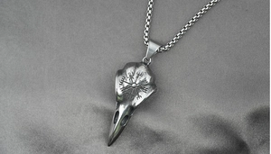 Macro view of Viking crow skull pendant with Vegvisir compass engraving and box chain