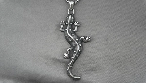 Detailed macro view of retro gecko pendant with realistic dotted texture and silver chain
