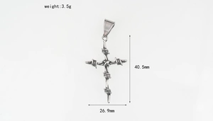 Dettaglio macro del ciondolo a croce di spine in argento con dimensioni e trama gotica