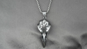Macro shot of retro bird skull pendant featuring Viking compass engraving on metal