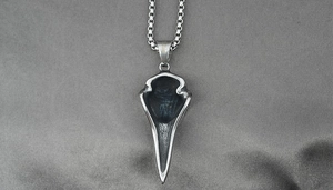Detail of bird skull pendant in stainless steel with S.Steel engraving on grey fabric