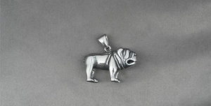 Macro d'un pendentif bouledogue argenté montrant les plis du visage et la forme musclée