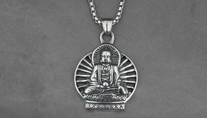 Macro view of vintage silver Buddha pendant with intricate textured lotus patterns