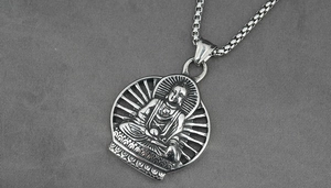 Macro view of vintage silver Buddha pendant with intricate lotus seat and box chain link