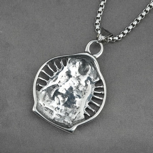 Retro titanium steel necklace with Buddha relief pendant on textured grey fabric