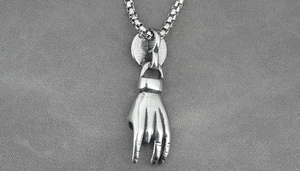 Detail of silver rock-on hand gesture pendant with vintage box chain for men