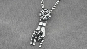 Macro view of vintage stainless steel evil eye hand pendant and engraved Om symbol