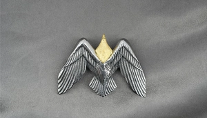 Vue détaillée du pendentif aigle vintage avec finitions texturées en or et argent