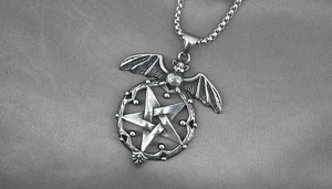 Detailed macro view of vintage gothic bat and pentagram pendant with oxidized silver finish