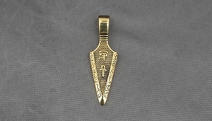 Macro shot of Egyptian Eye of Horus and Ankh symbols on a vintage gold pendant