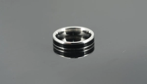 Close-up of titanium steel ring with polished silver finish and black enamel inlay