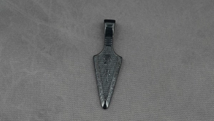 Macro view of matte black arrowhead pendant with Eye of Horus and Ankh engravings