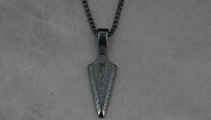 Detail shot of black gothic arrow pendant with Egyptian pharaoh and ankh engravings