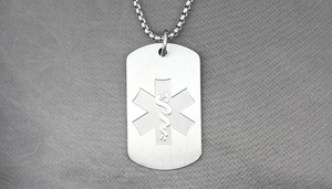 Macro shot of silver stainless steel dog tag pendant with engraved medical star of life symbol