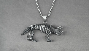 Detailed close-up of a vintage triceratops skeleton pendant on a square pearl chain