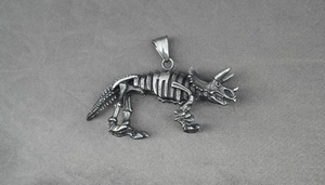 Macro shot of retro stainless steel triceratops skeleton pendant with aged metal texture