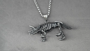 Detailed macro view of vintage stainless steel triceratops skeleton pendant and chain
