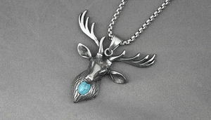 Détail du pendentif tête de cerf argenté vintage avec turquoise sur chaîne acier