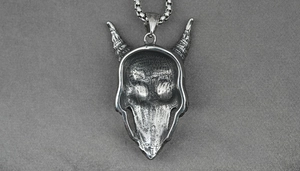 Macro shot of gothic titanium steel skull pendant with vintage silver finish on metal chain
