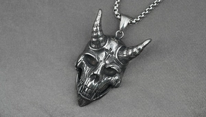 Detail showing retro silver skull pendant with cross engraving and chunky pearl chain link