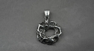 Détail macro du pendentif dragon en argent vintage avec écailles et finition sombre